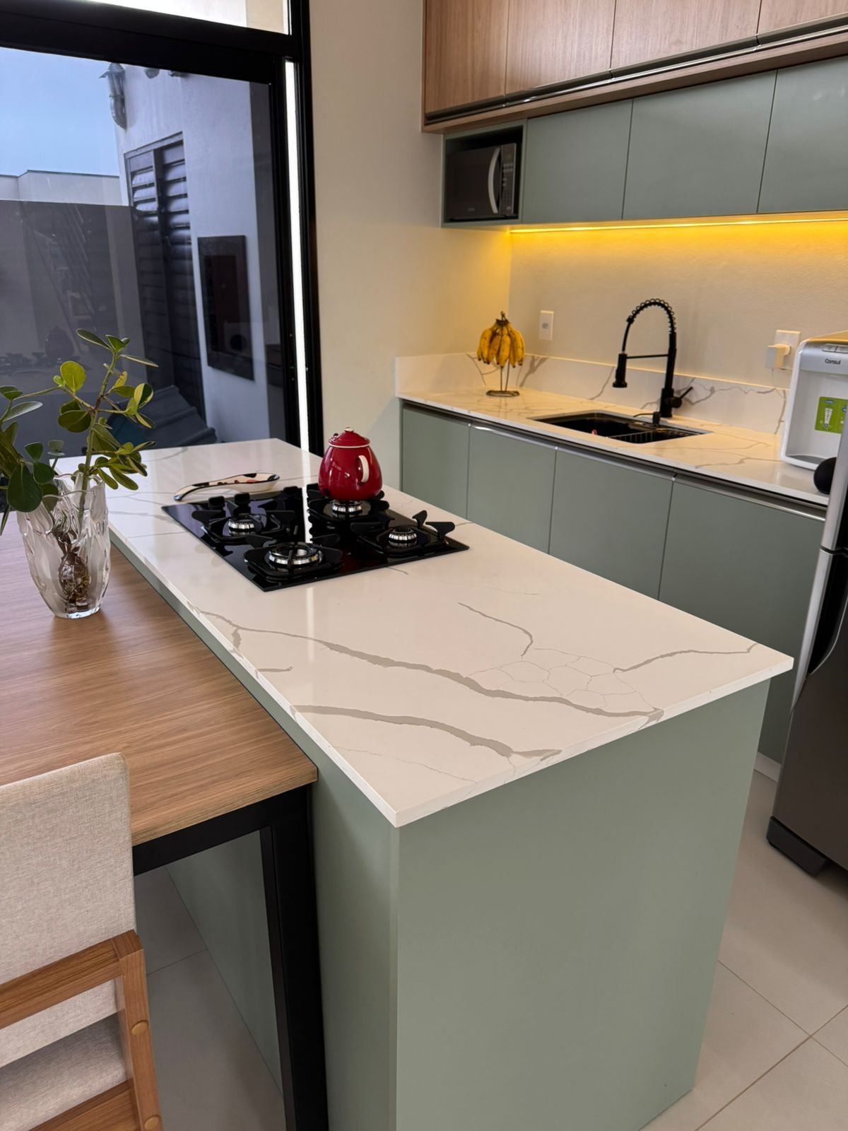 Cozinha verde com bancada em pedra clara